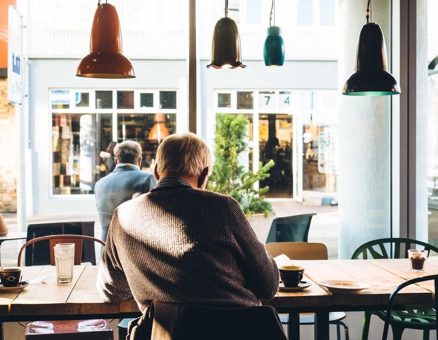 A man sitting at a table inside a bright cafe