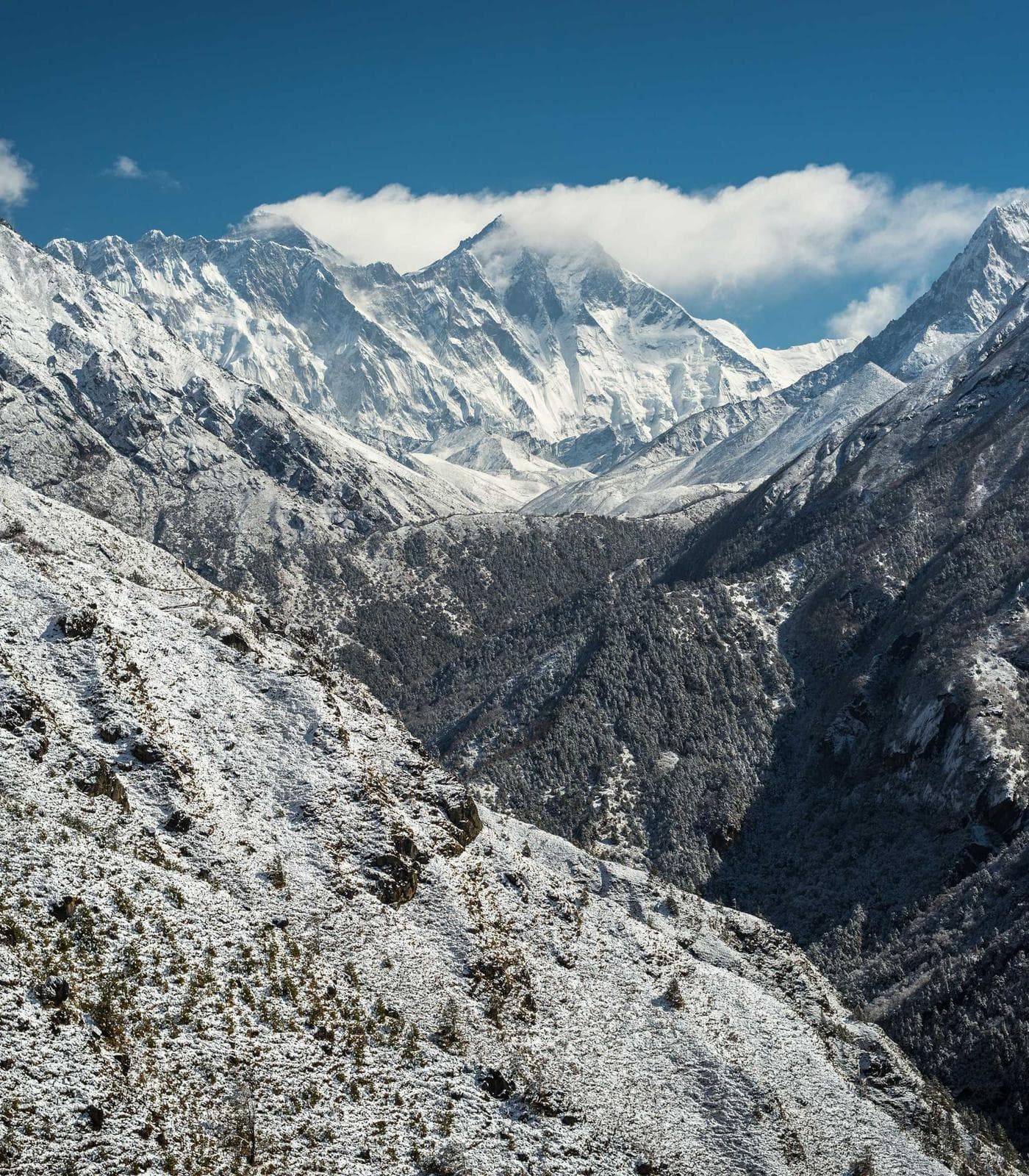 Snow-covered mountain range under a pale sky